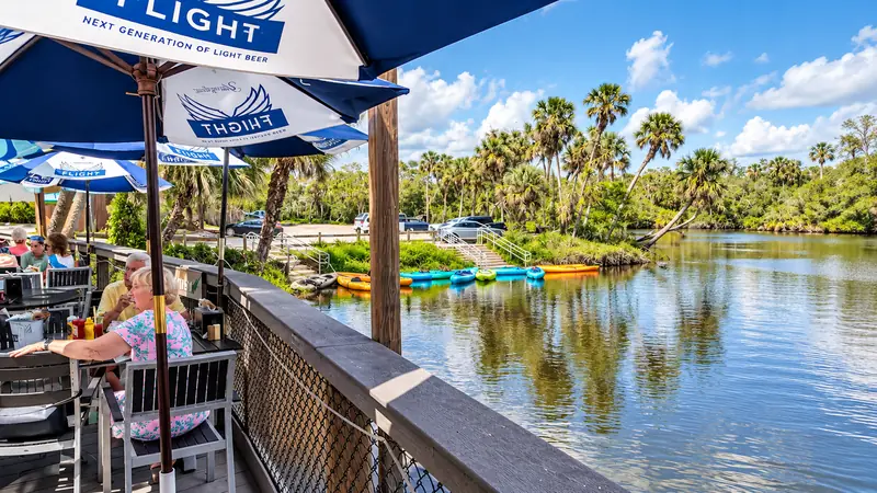 View from a shaded riverside deck toward the water