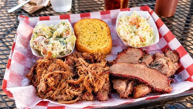 Barbecue platter with smoked meats, garlic bread, potato salad and coleslaw